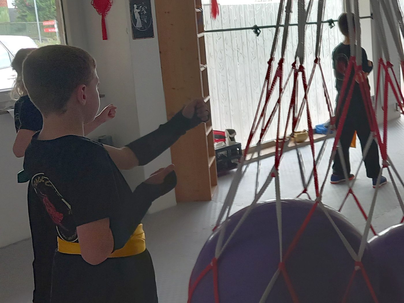 Kind im Dragon-Cave-Anzug mit gelber Schärpe in der Kung-Fu-Grundstellung