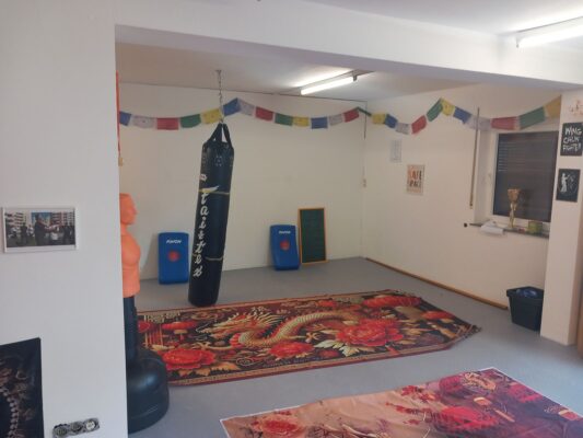 Trainingsraum der Kung-Fu-Schule in Wittelsberg mit Sandsack, Drachenteppich und Gebetsfahnen